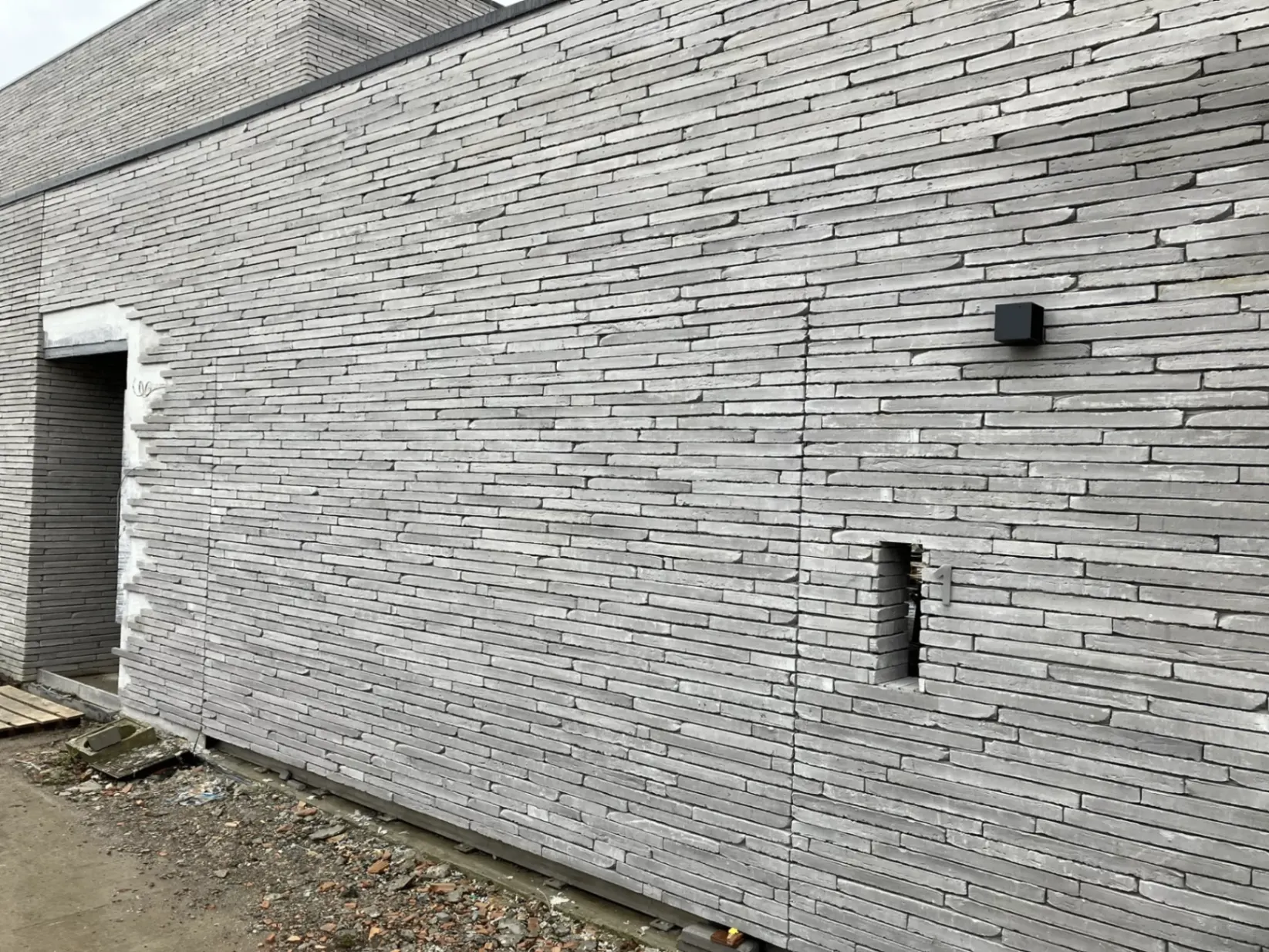 Onzichtbare garagepoort met natuurstenen bekleding