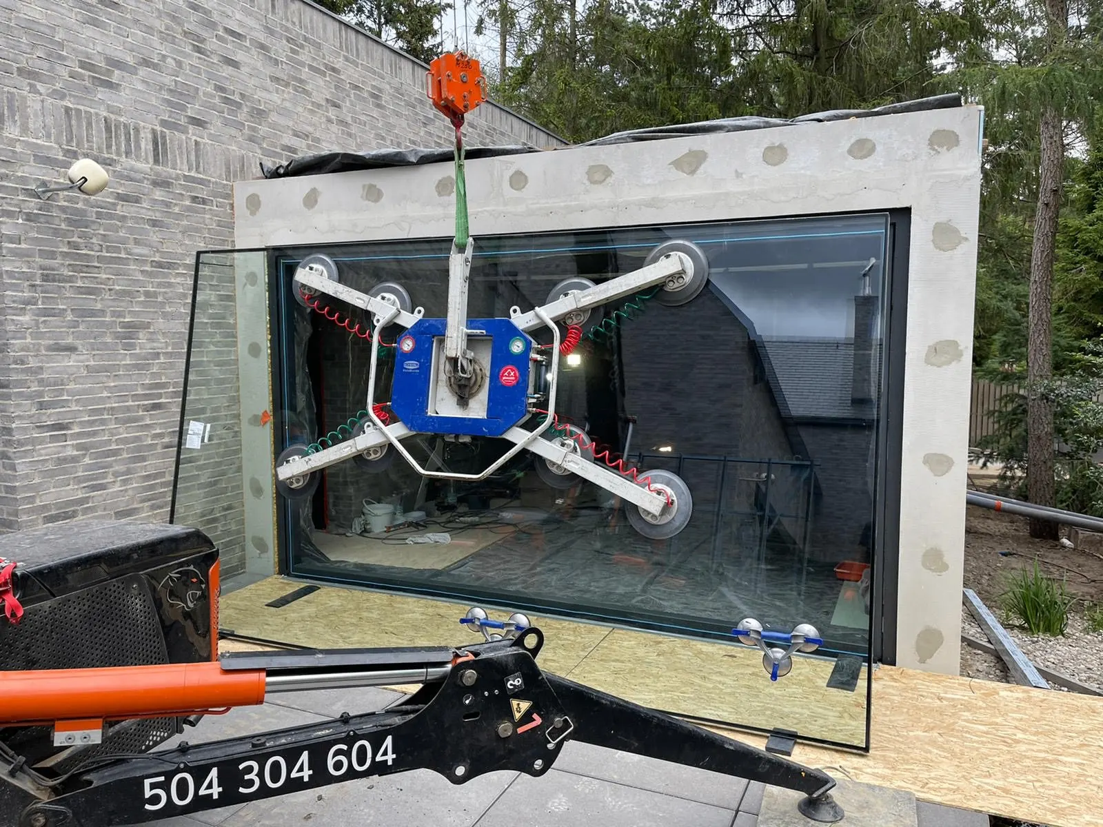 Installatie van een grote glazen garagepoort met vacuümzuignappen